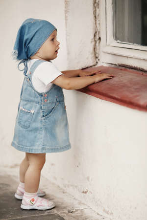 young girl looks to windowの写真素材