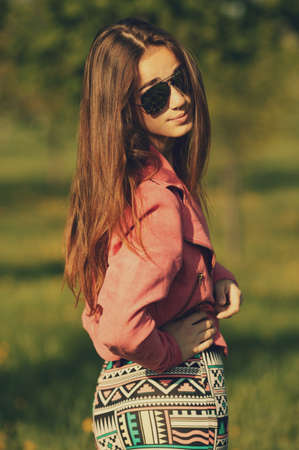 beautiful young girl with sunglasses in dandelion fieldの写真素材