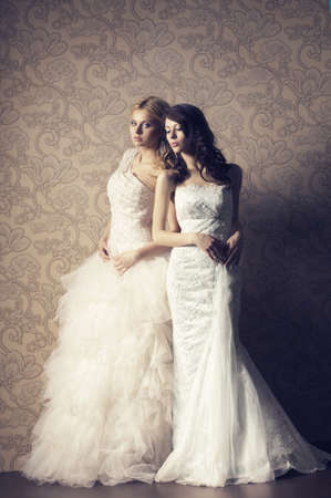 blonde and brunette bride on floral vintage backgroundの写真素材