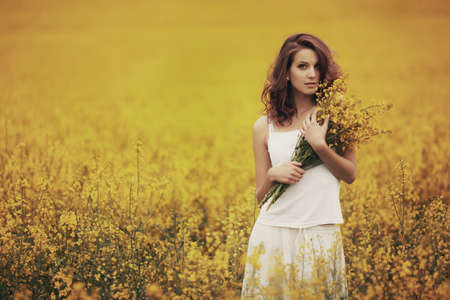 young beautiful girl in yellow fieldの写真素材