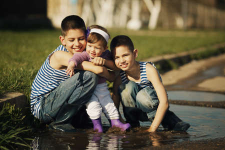 little happy children playing in the puddleの写真素材