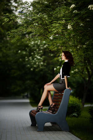 young beautiful girl sitting on benchの写真素材