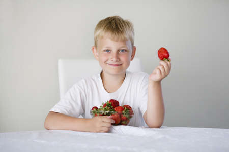 little funny boy with strawberriesの写真素材