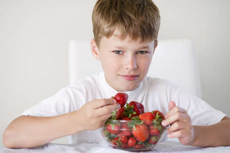 little funny boy with strawberriesの写真素材
