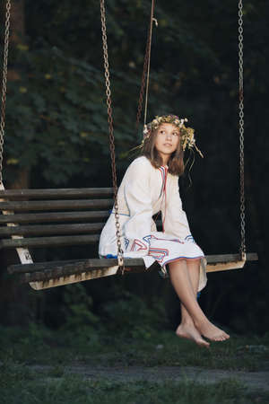 young beautiful girl riding on swingの写真素材