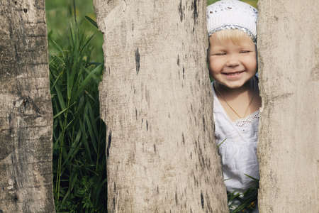 cute little girl and wooden fenceの写真素材