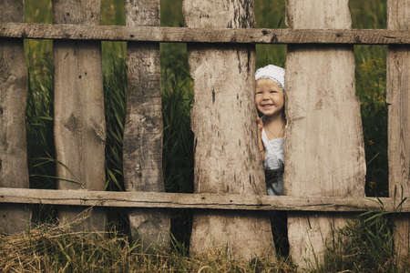 cute little girl and wooden fenceの写真素材