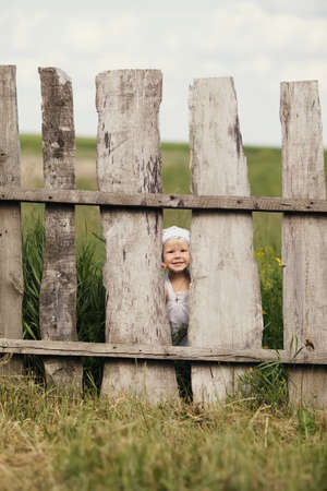cute little girl and wooden fenceの写真素材