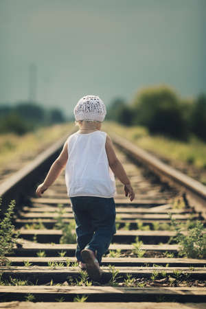 little beautiful girl plays on railroadの写真素材