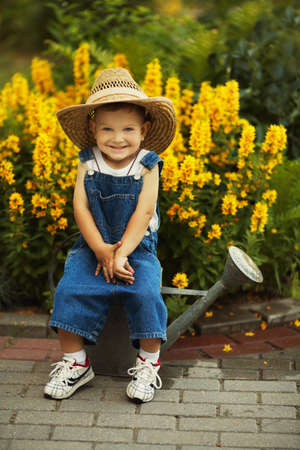 cute little boy watering flowers watering canの写真素材