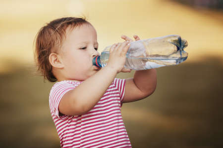 little girl with bottle of mineral waterの写真素材