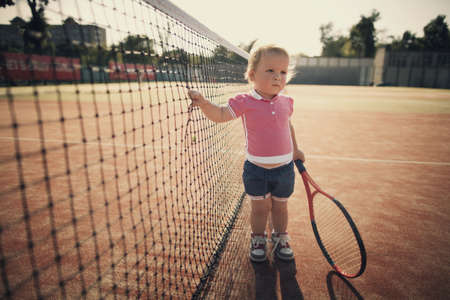 little funny girl with tennis racketの写真素材