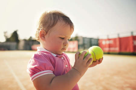 little funny girl with tennis ballの写真素材