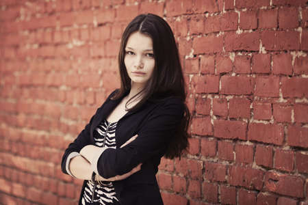 beautiful girl near red brick wall portrait