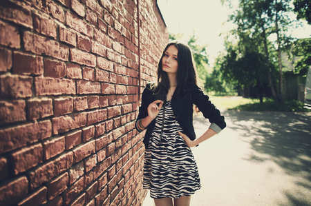 beautiful girl near red brick wall portrait
