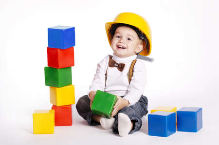 little engineer with protective helmet plays with cubesの写真素材