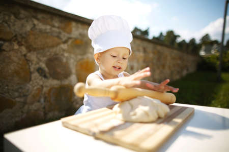 cute little boy with chef hat cookingの写真素材