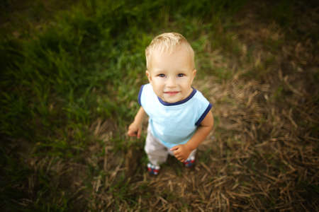 sad little boy portrait in high grassの写真素材