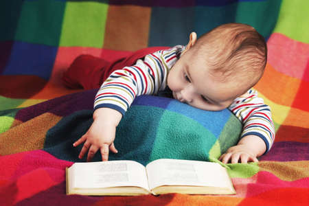 cute baby reading book on colorful background