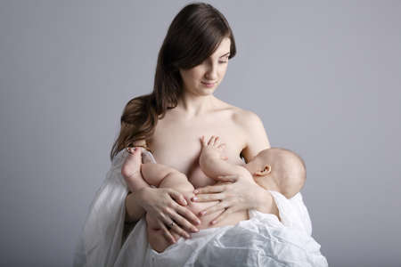 Mother breast feeding her infant studio shotの写真素材