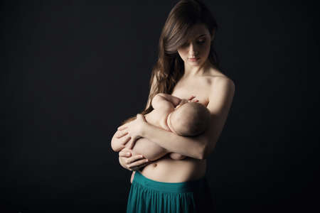Mother breast feeding her infant studio shotの写真素材