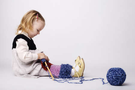 cute little girl knitting scarfの写真素材