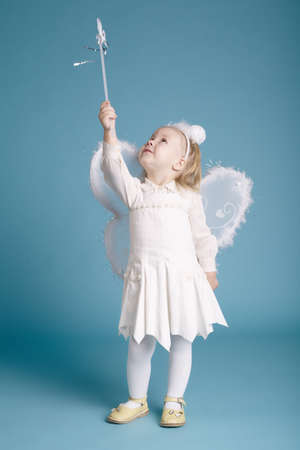 Cute little girl with butterfly costume on blue wallの写真素材