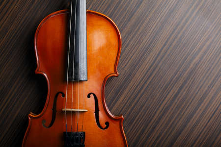aged handmade violin on wooden table の写真素材