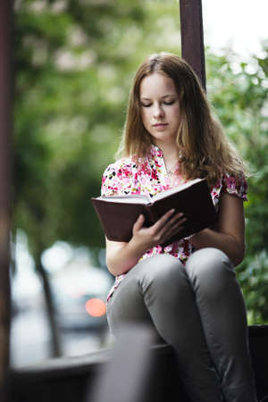 beautiful blond girl reading book 