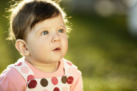 cute sweet baby sitting on grass in garden