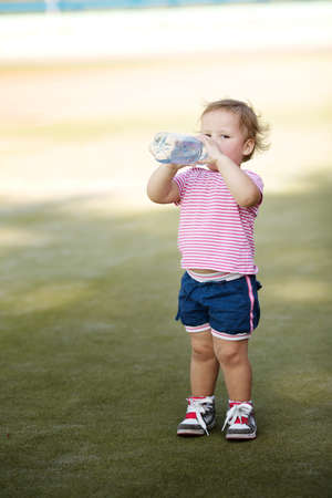 little girl with bottle of mineral waterの写真素材