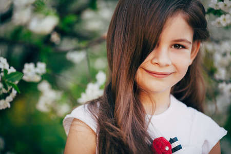 little pretty girl stay near the cherry tree and smilingの写真素材