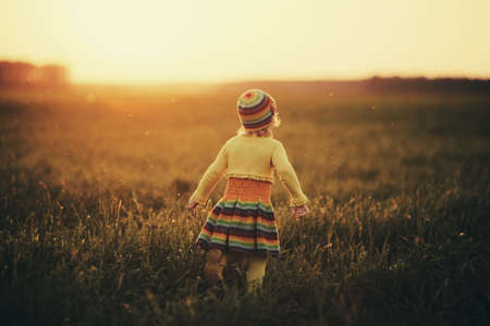 little girl runnig to the sunsetの写真素材