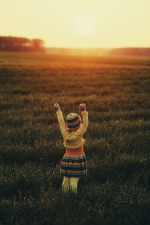 little girl runnig to the sunsetの写真素材