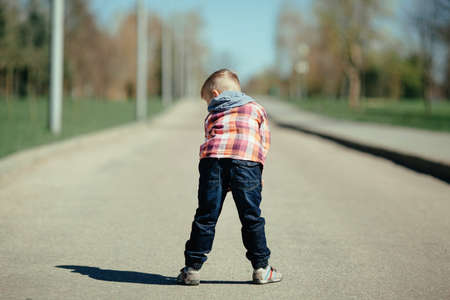 little cute boy stay back and ape on the streetの写真素材