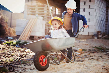 boy and girl playing on construction siteの写真素材