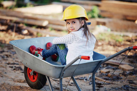 girl riding in the construction wheelbarrowの写真素材