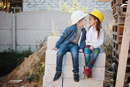 boy and girl playing on construction siteの写真素材