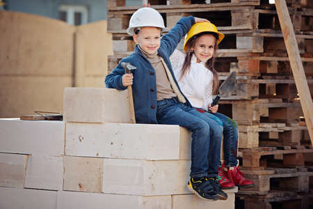 boy and girl playing on construction siteの写真素材