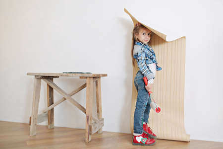 Cute little girl hanging wallpaperの写真素材