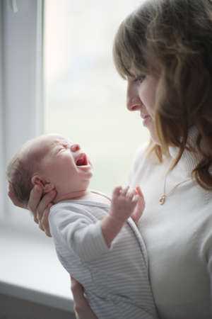 young mother with crying babyの写真素材