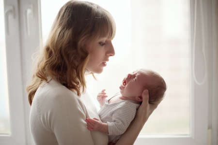 young mother with crying babyの写真素材