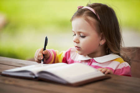 cute little girl learning to writeの写真素材
