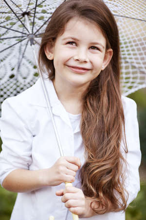 pretty girl with lace umbrella in white suitの写真素材