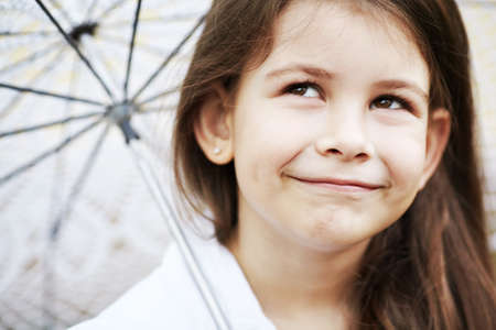 pretty girl with lace umbrella in white suitの写真素材