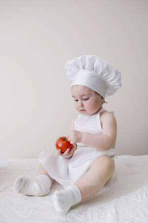 cute little cook eats tomatoの写真素材