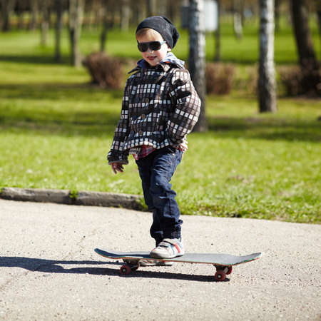 little boy with skateboard on the street