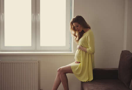 beautiful pregnant woman at home portraitの写真素材