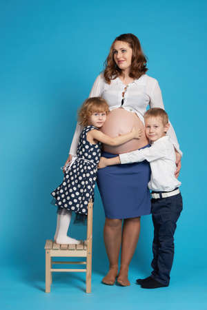 young boy and girl hug pregnant motherの写真素材