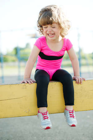 little unhappy girl crying on the playground